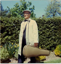 A photograph of Fred DiLucci, W1GLO(SK) carrying a violin case